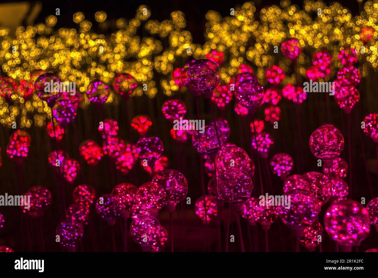 Globi di vetro rosa con sfondo bokeh sfocato dorato Foto Stock