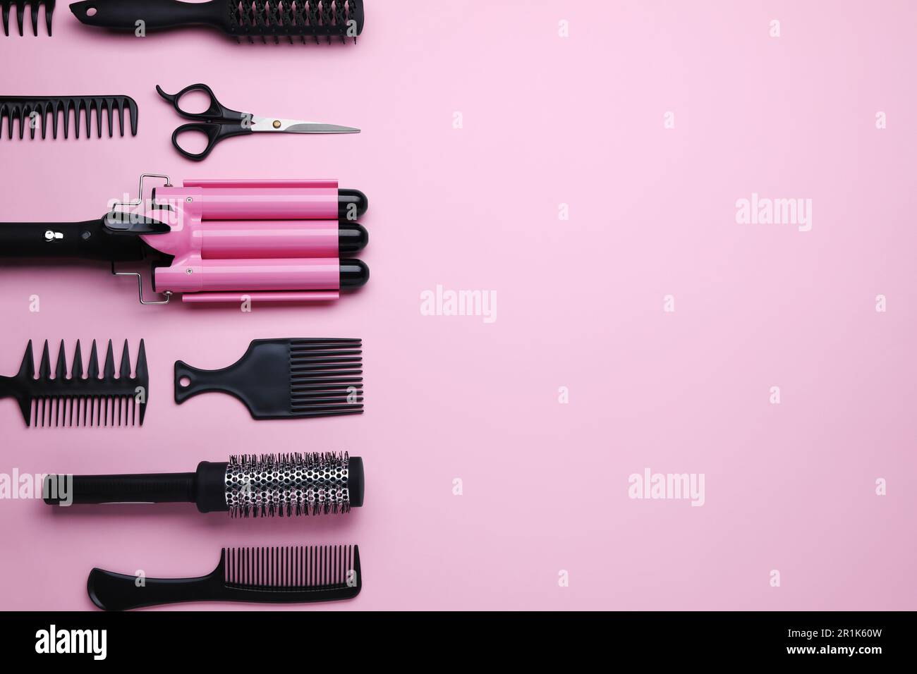 Composizione a posa piatta con moderno ferro arricciacapelli triplo su  sfondo rosa, spazio per il testo Foto stock - Alamy