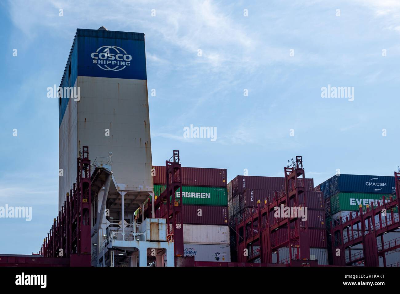 Amburgo, Germania - 04 17 2023: Primo piano della sovrastruttura di una nave portacontainer con il logo di cosco Shipping e vari contenitori Foto Stock