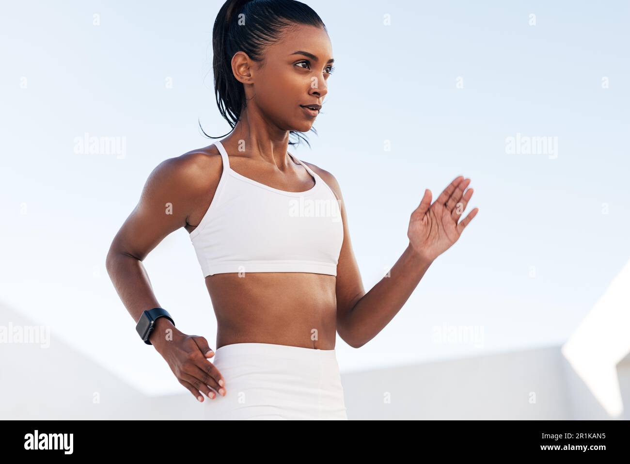 Primo piano di una giovane donna in un reggiseno sportivo che fa esercizi di riscaldamento. Ritagliato di un atleta di fitness professionista che si esercita all'aperto. Foto Stock