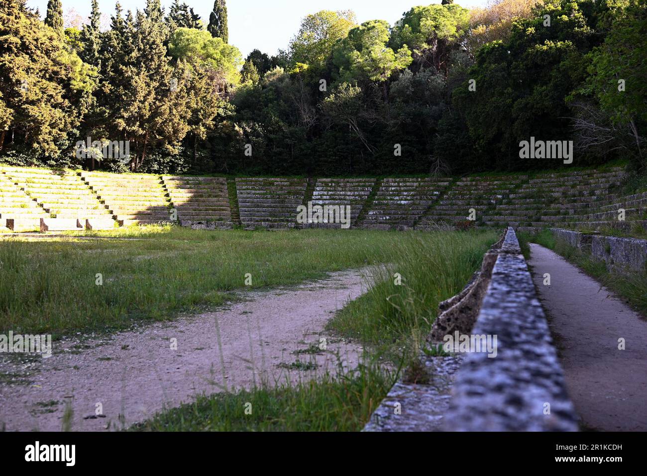 Un antico stadio greco in pietra rappresenta il pentathlon degli atleti antichi. Lo stadio è circondato da file di thuja e cespugli di alloro. Foto Stock