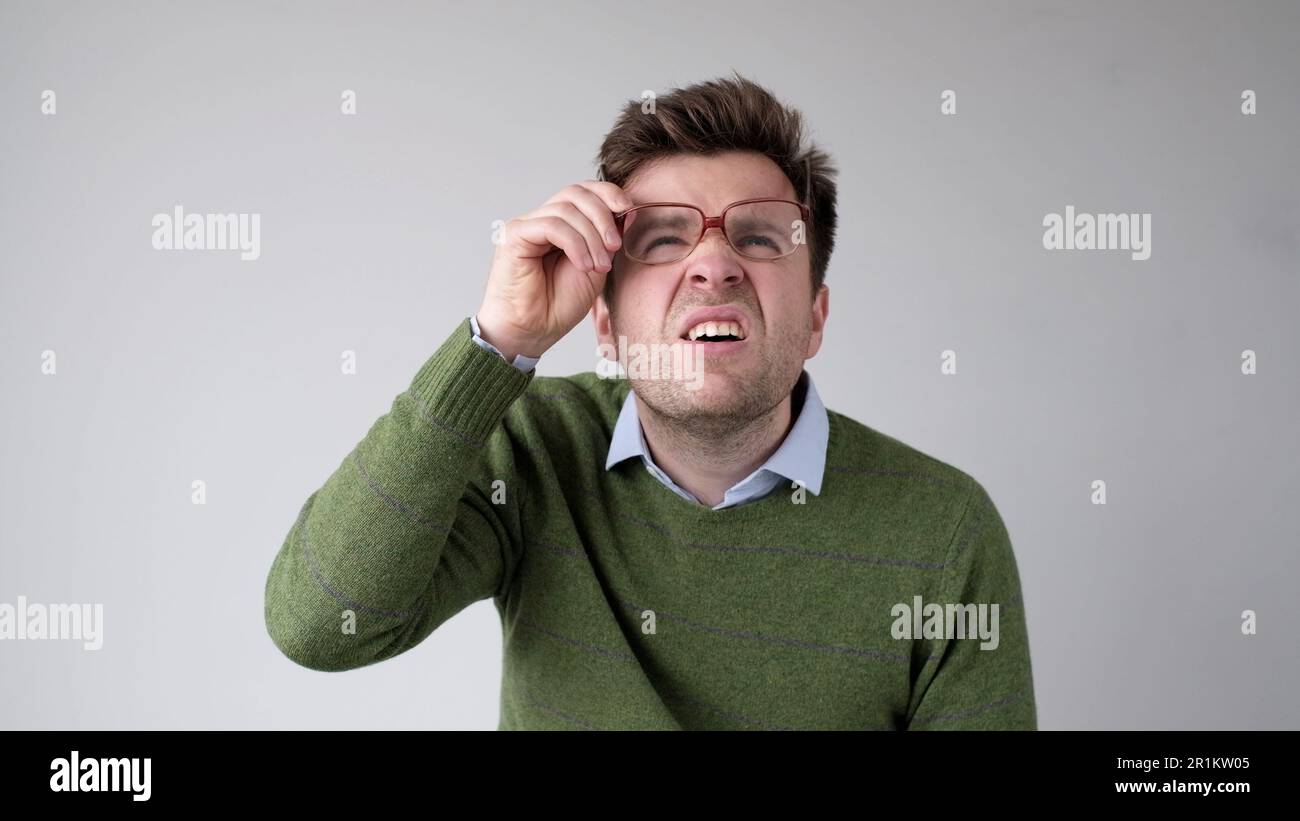 Un giovane europeo con una visione povera si collega attraverso i suoi occhiali, cercando di discernere le informazioni che gli interessano Foto Stock