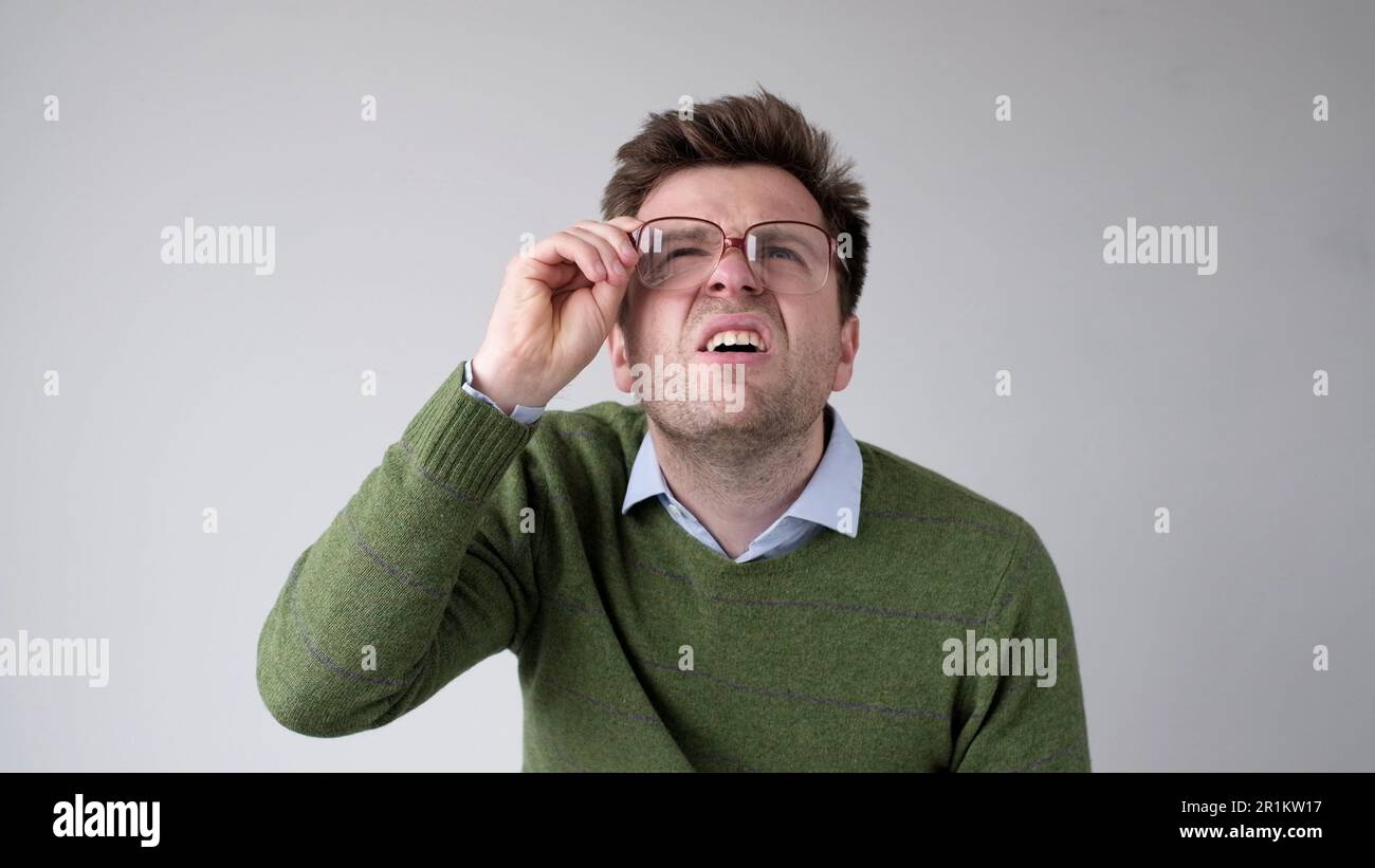 Un giovane europeo con una visione povera si collega attraverso i suoi occhiali, cercando di discernere le informazioni che gli interessano Foto Stock