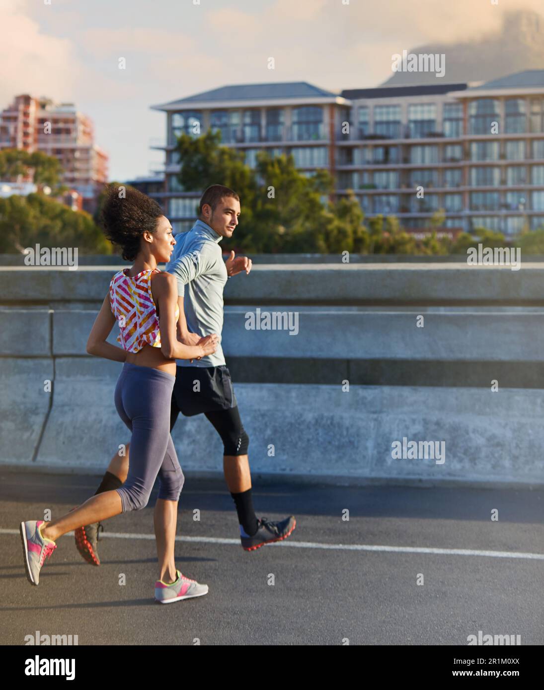 HES a un ritmo sostenuto. due amici che corrono insieme per le strade della città. Foto Stock