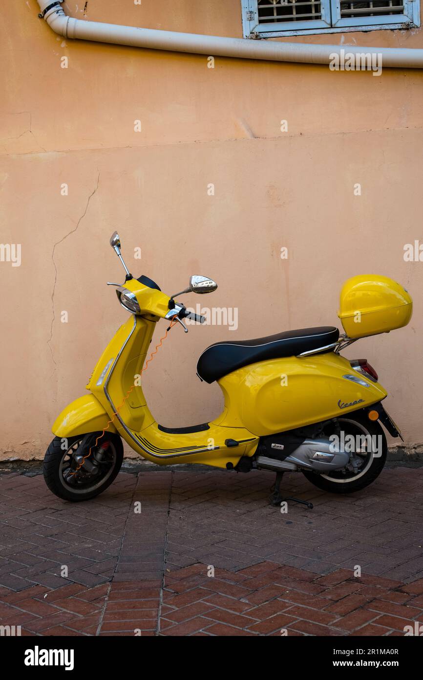 Scooter giallo brillante su uno sfondo chiaro e di colore caldo Foto Stock
