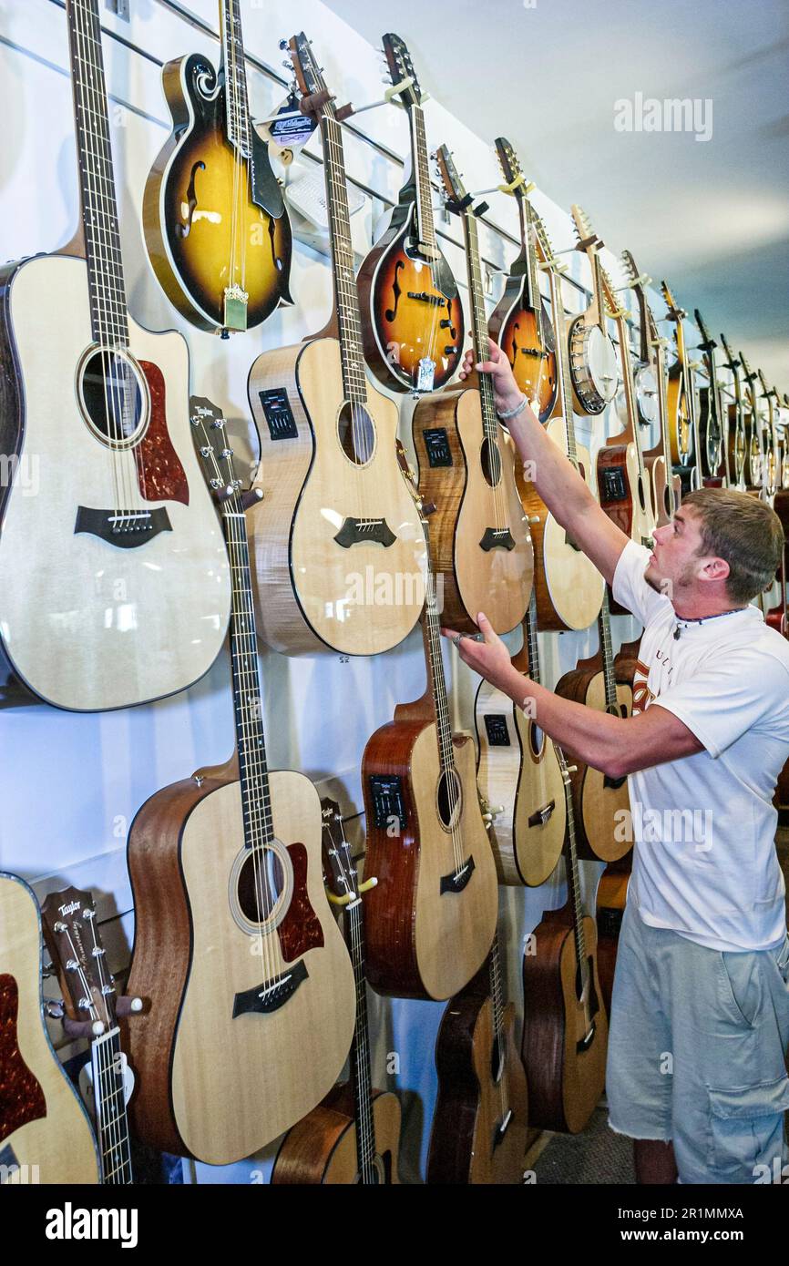 Sevierville Tennessee,Music Outlet store business strumenti musicali vendita shopping,interni,chitarre display uomo cliente maschile, Foto Stock