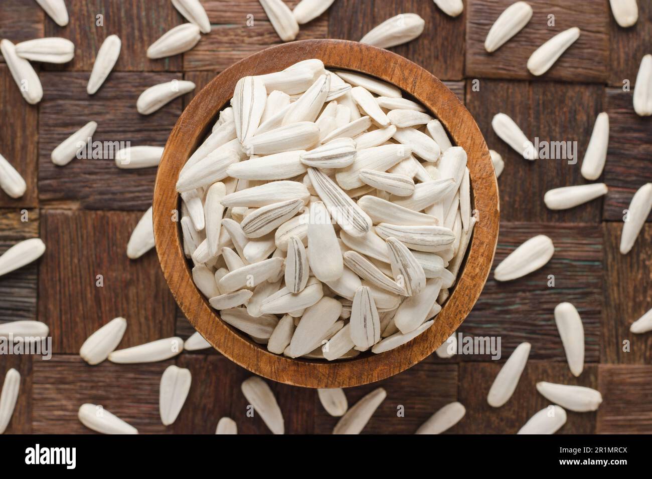 semi di girasole bianchi in ciotola su sfondo di tavolo di legno. Foto Stock