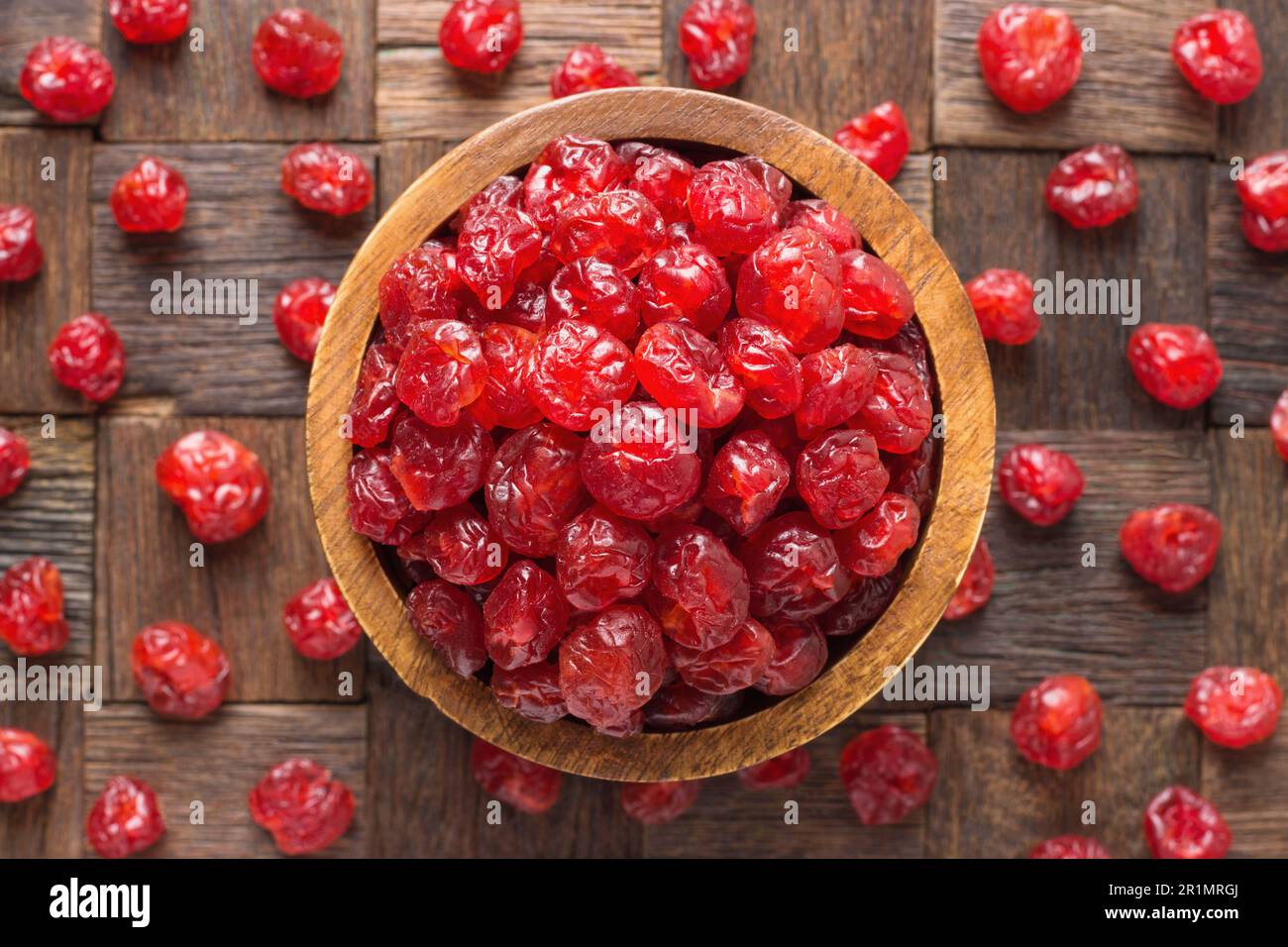 frutta candita, ciliegia secca con zucchero in ciotola su fondo di tavola di legno. Foto Stock