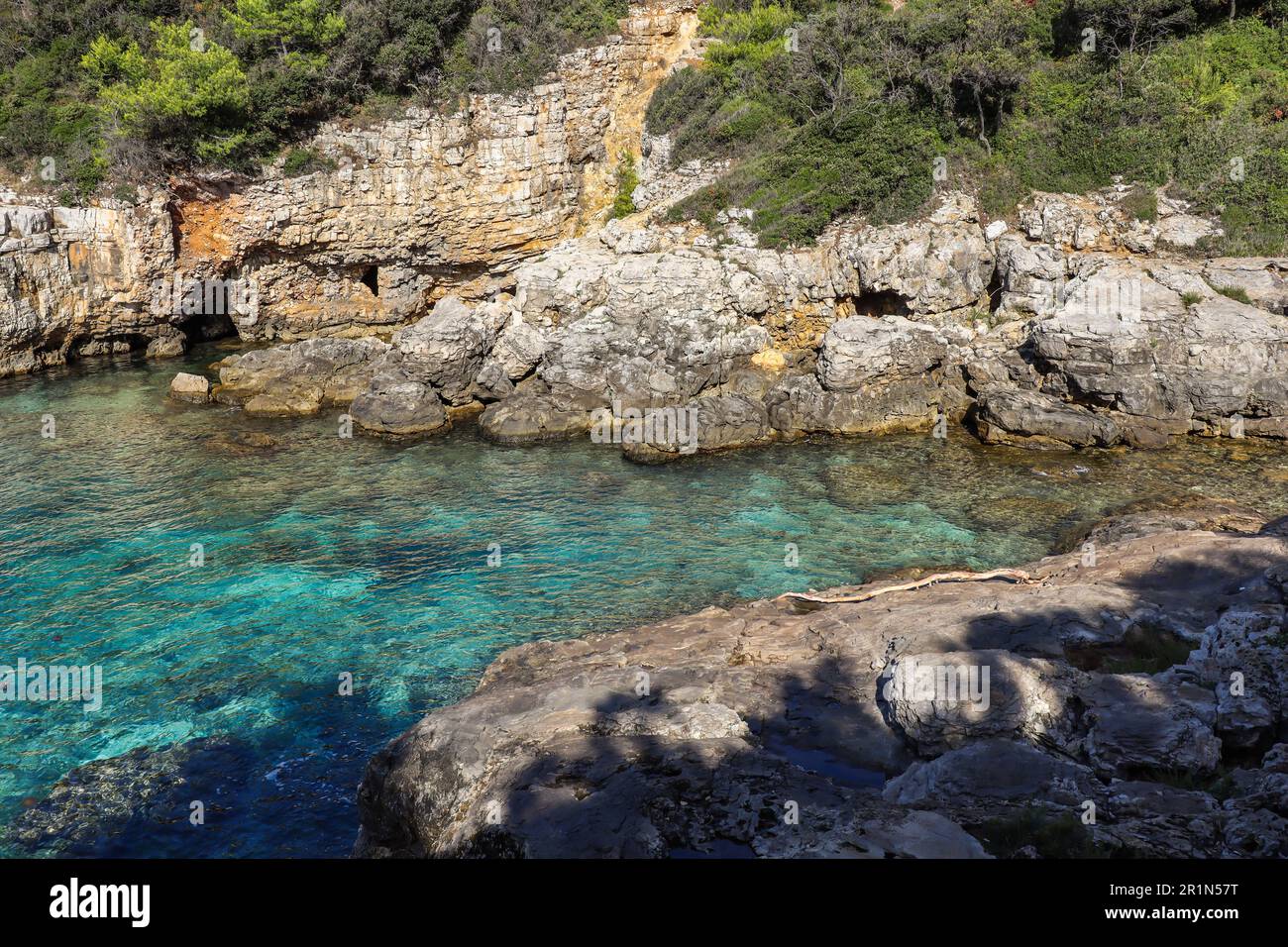 Mare Adriatico turchese con rocce a Pola natura. Acque limpide con paesaggio roccioso durante il giorno estivo del sole in Croazia. Foto Stock