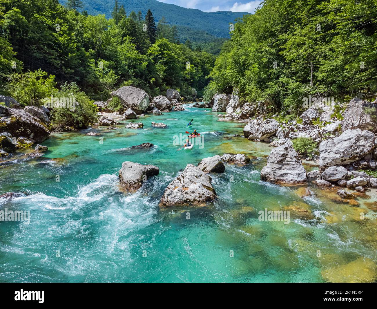 Valle Soca, Slovenia - veduta aerea del fiume alpino smeraldo Soca con barche da rafting che scendono lungo il fiume in una giornata estiva di sole Foto Stock