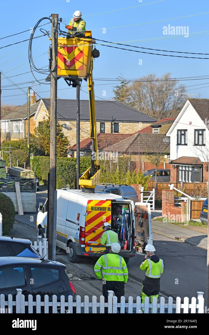 Elettrotecnici appaltatori che sostituiscono TUTTI i cavi di alimentazione elettrica obsoleti e pali di supporto per le case residenziale via Inghilterra Regno Unito Foto Stock