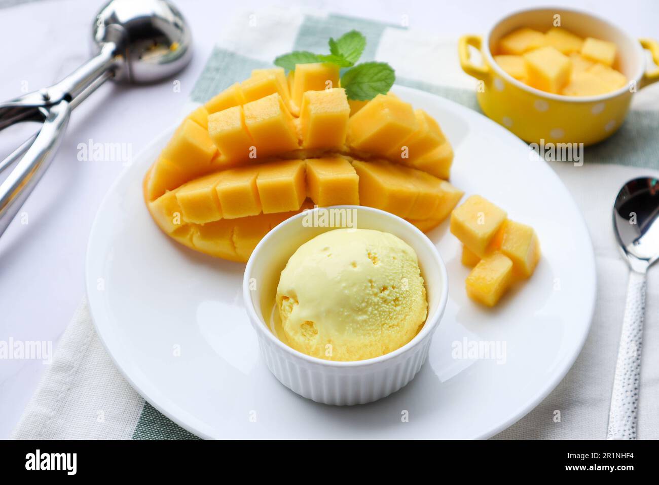Gelato al mango con mango maturo sul lato in un piatto bianco - vista ravvicinata del dessert Foto Stock