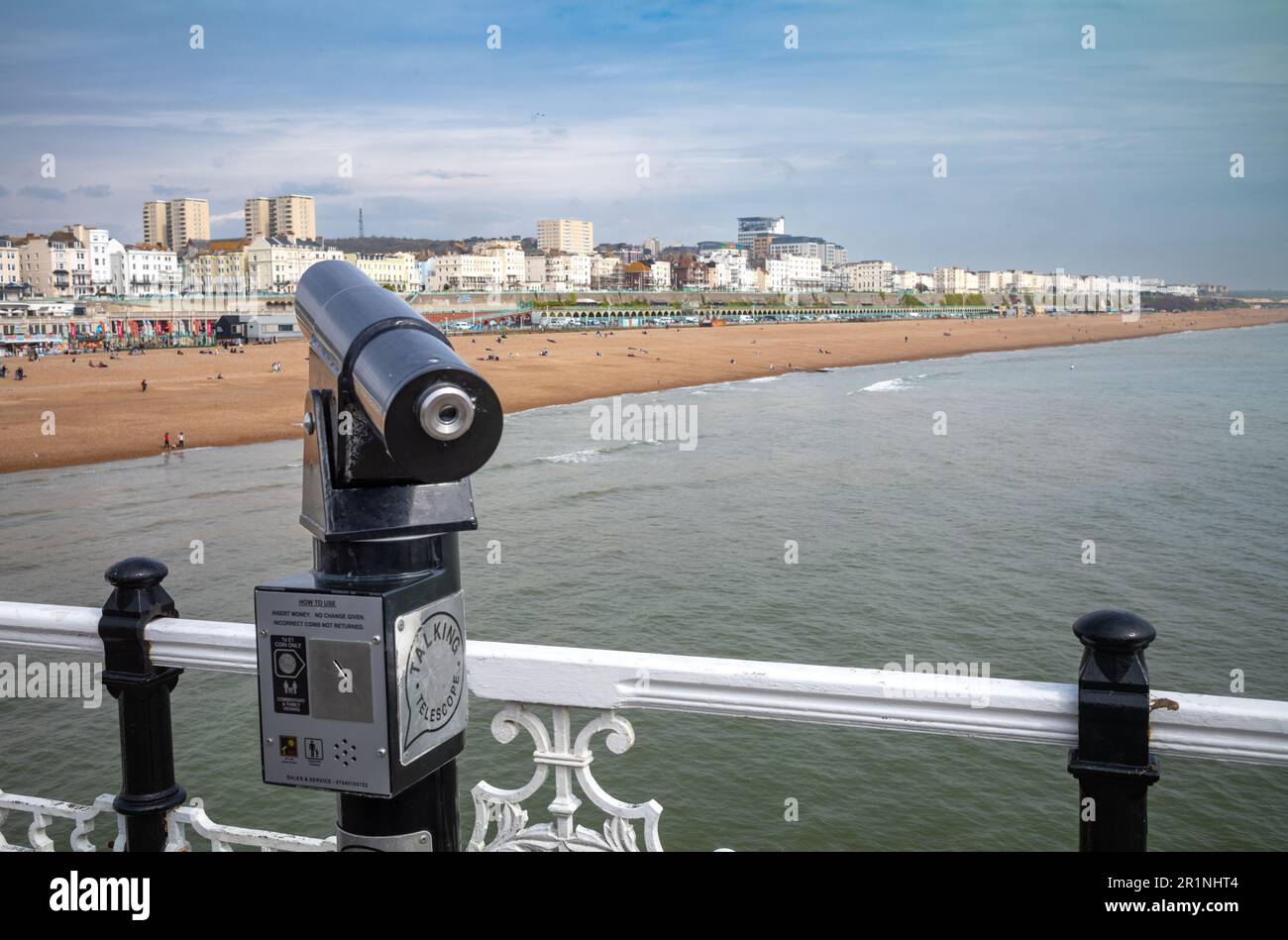 Un telescopio a gettoni sul molo di Brighton punta verso la spiaggia e il lungomare di Brighton, East Sussex, Regno Unito. Il molo risale al 1899 Foto Stock
