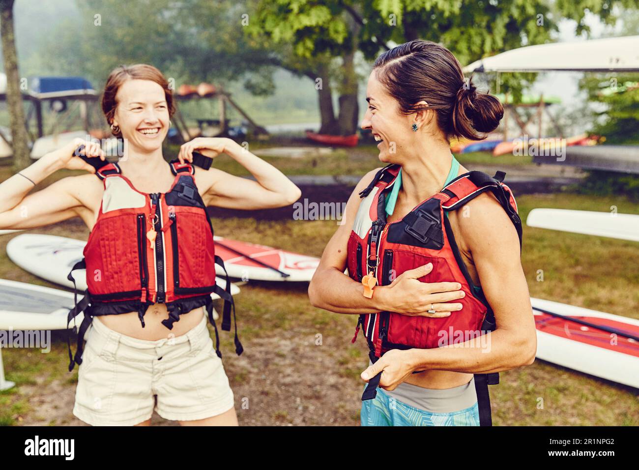 Le giovani donne indossano i giubbotti di salvataggio in preparazione al viaggio in kayak Foto Stock