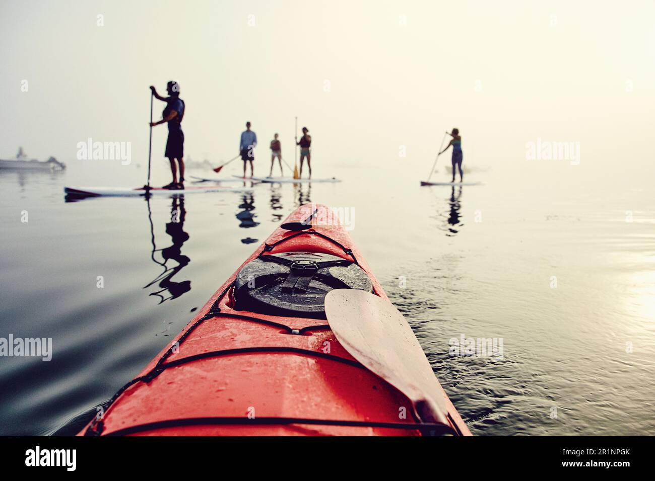 Un gruppo di pedalò e di kayak in una mattinata nebbiosa Foto Stock