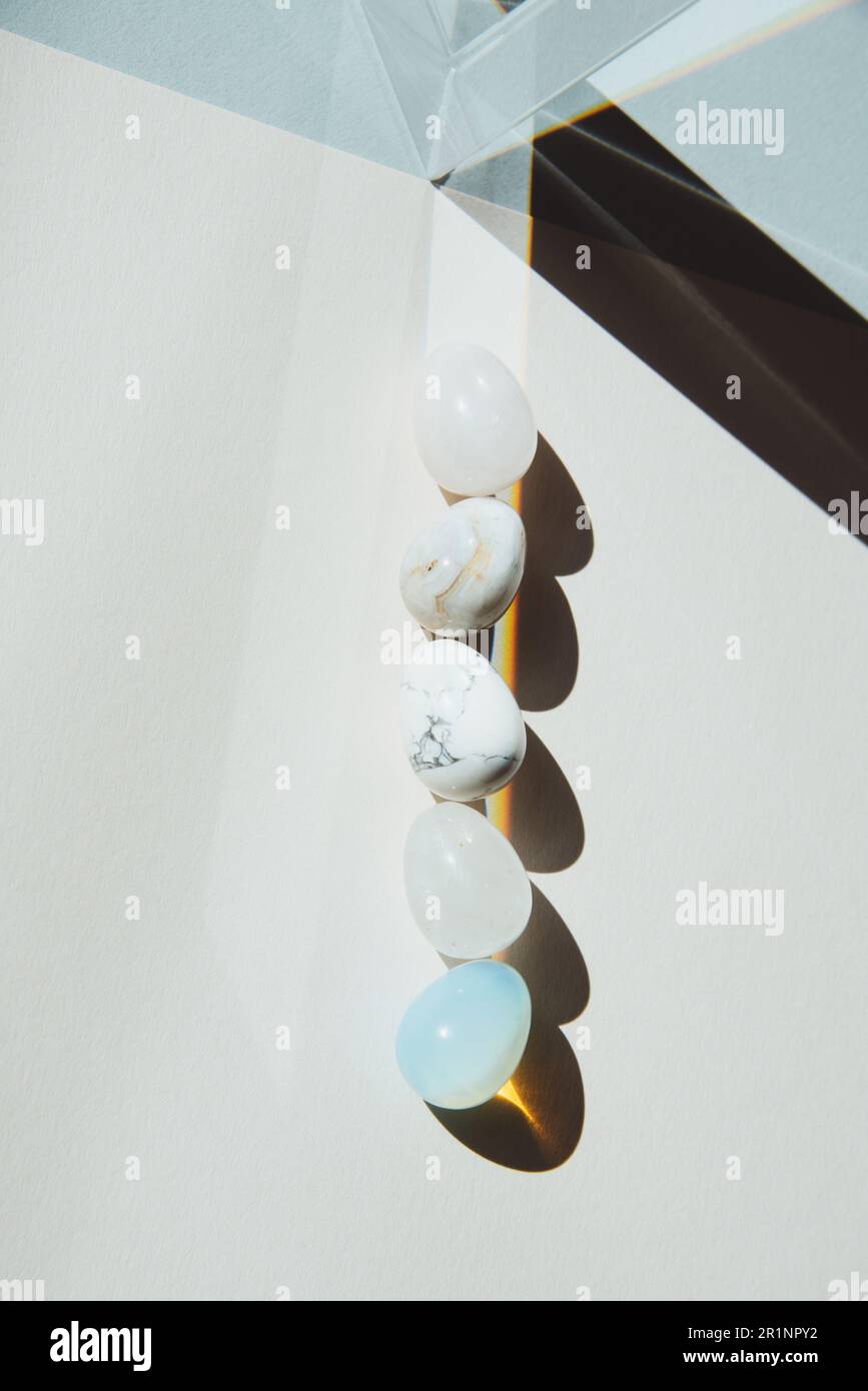 Variazione a forma di uovo di pietre con un prisma sotto una luce dura p Foto Stock