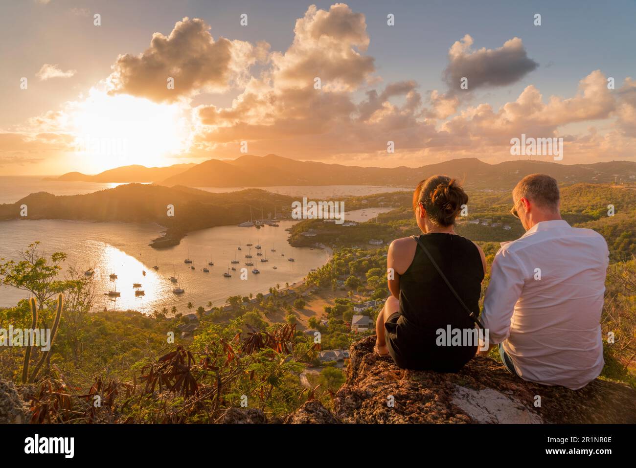 Uomo e donna che ammirano il tramonto su English Harbour, Antigua Foto Stock