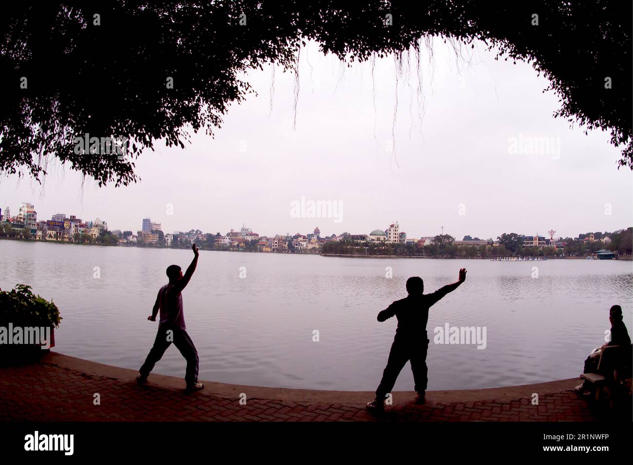 Tradizionale Tai Chi esercita la mattina presto Hanoi Truc Bach Lake Vietnam Foto Stock