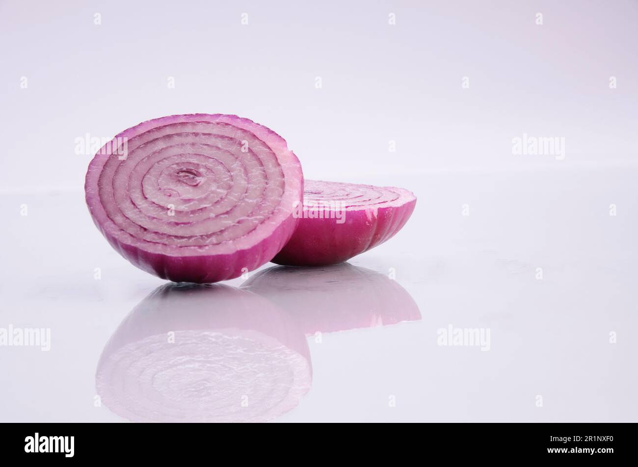 Una cipolla rossa tagliata di fresco isolata su fondo bianco. Foto Stock