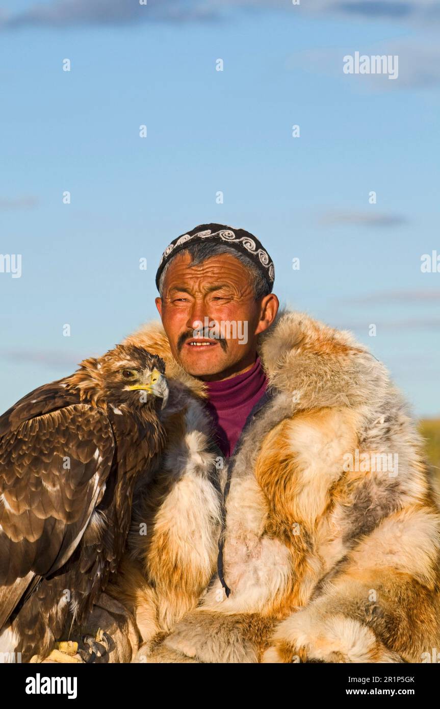Cacciatore kazako con Aquila reale (Aquila chrysaetos), Monti Altai, Bayan-Ulgii, Mongolia Occidentale Foto Stock