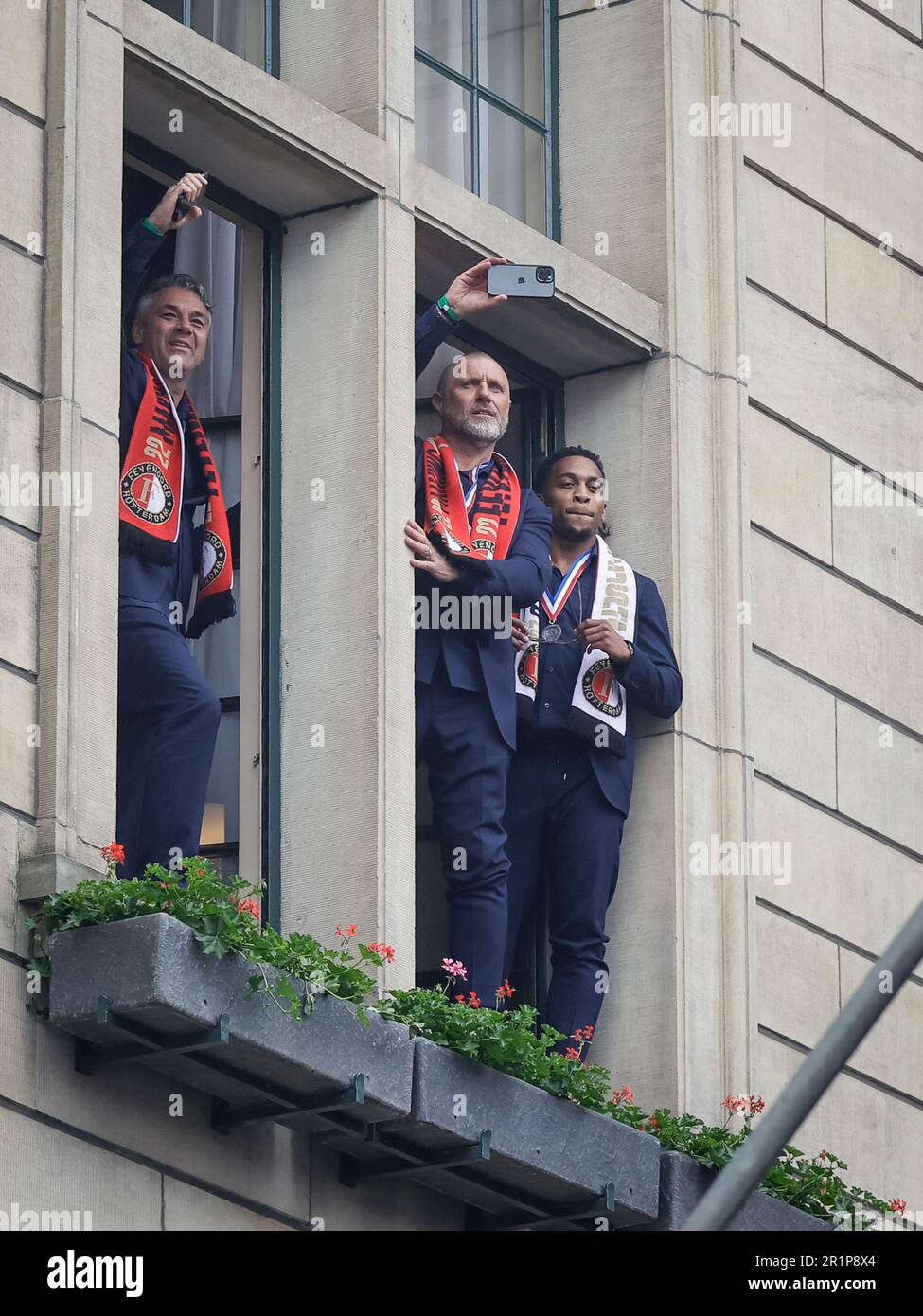 Rotterdam, Paesi Bassi. 15th maggio, 2023. Assistente allenatore Marino Pusic di Feyenoord, assistente allenatore John de Wolf di Feyenoord e Quinten Timber di Feyenoord sono visti in piedi in una cornice di una finestra durante un evento di Celebrazione al Coolsingel il 15 maggio 2023 a Rotterdam, Paesi Bassi, A festeggiare il campionato di Feyenoord dopo aver vinto il titolo 2022-2023 Eredivie. (Foto di Broer van den Boom/Orange Pictures) Credit: Orange Pics BV/Alamy Live News Foto Stock