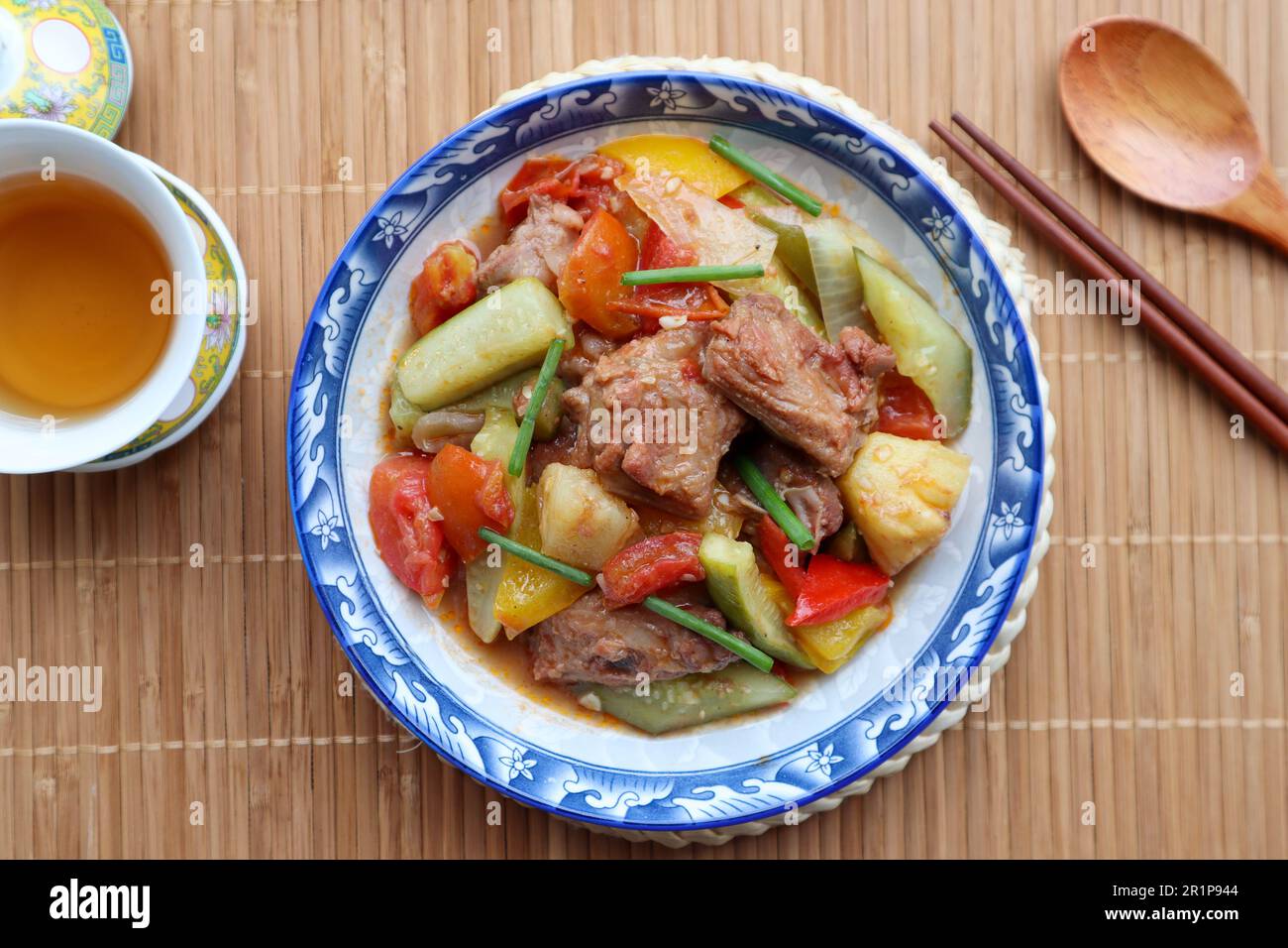Maiale dolce e acido - famoso piatto cinese su placemat di bambù Foto Stock