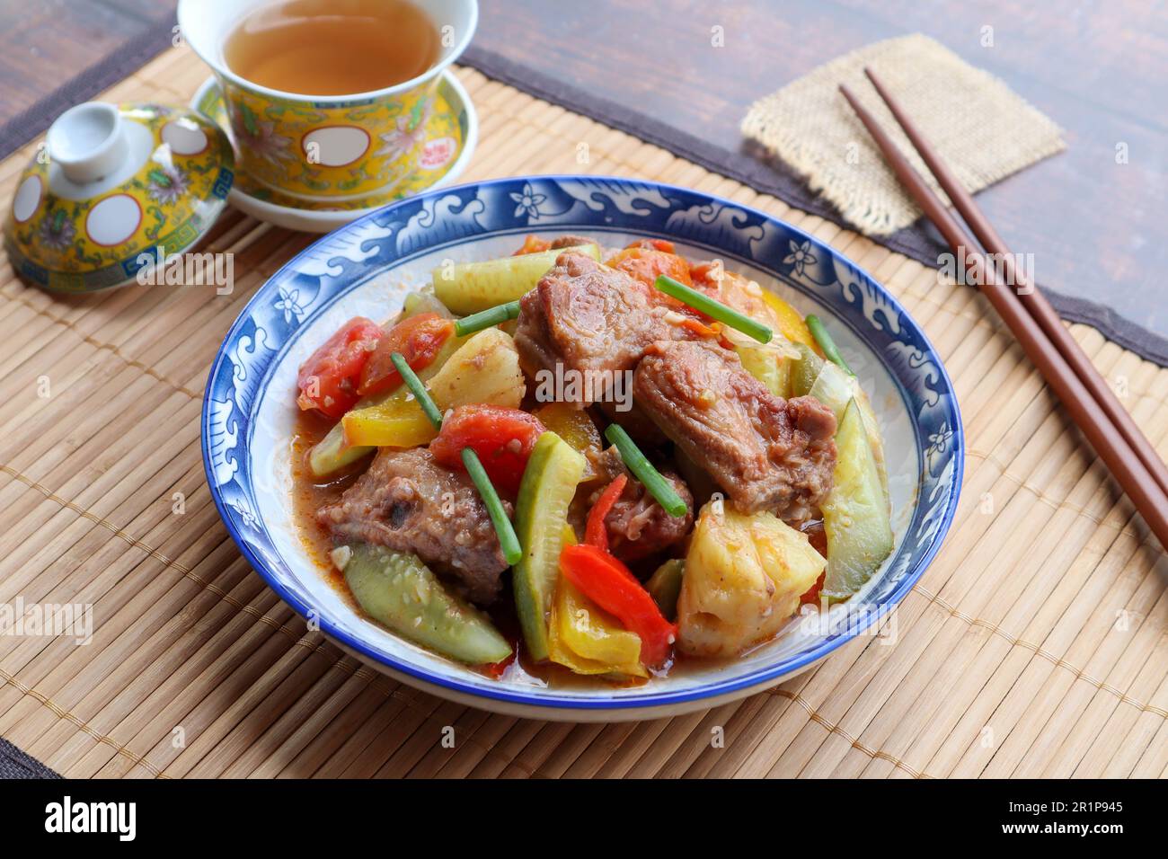Maiale dolce e acido - famoso piatto cinese cantonese su placemat di bambù Foto Stock