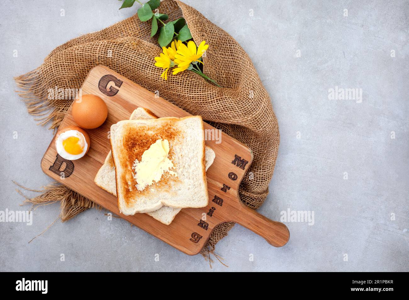 Buona colazione. Uova bollite e toast su asse di legno con testo. Rustico sul grigio Foto Stock