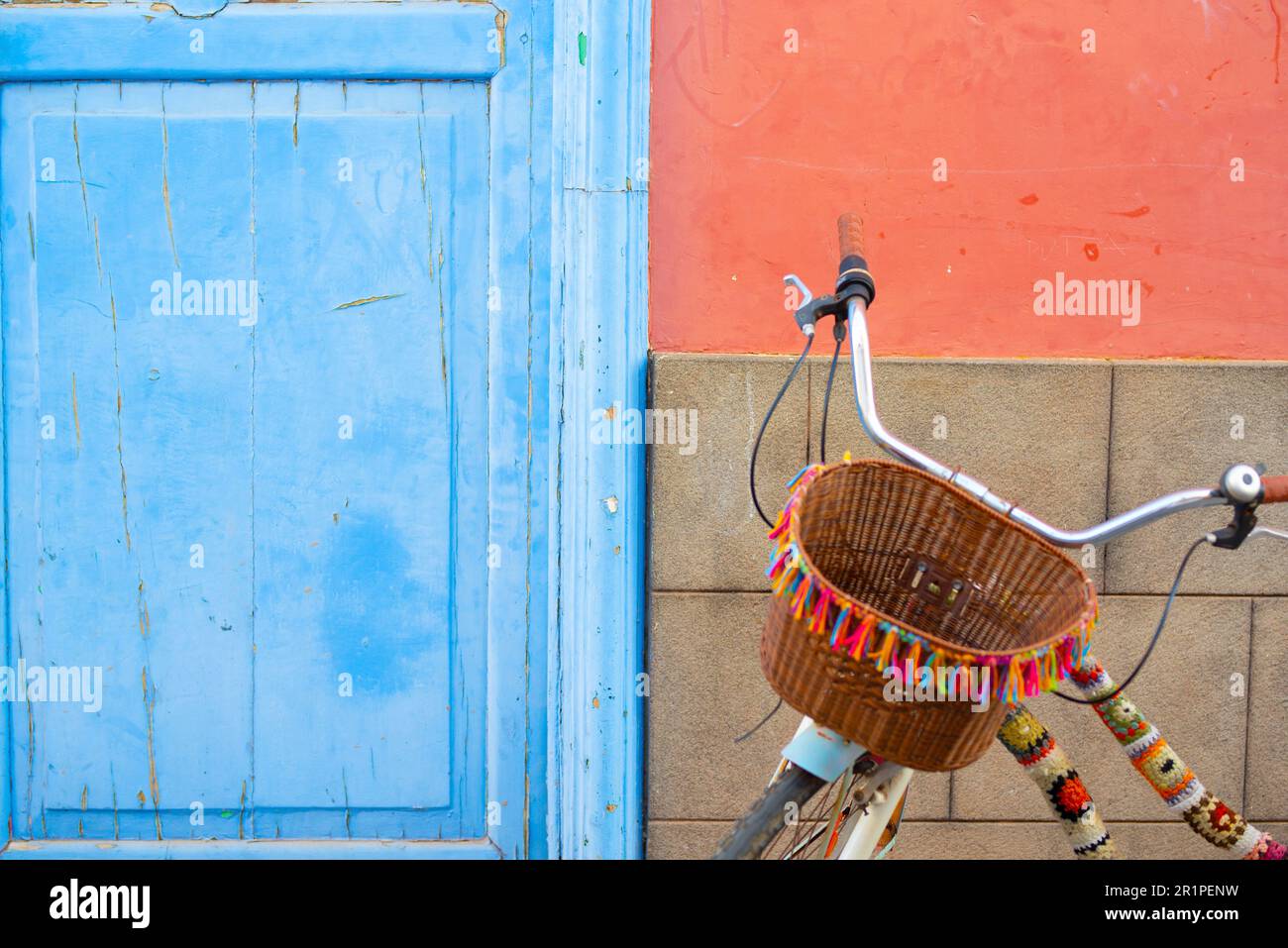 Immagine sfondo colorato con bicicletta, porta e parete. Carta da parati multicolore concetto di trasporto stile di vita sano e proprietario della casa. Spazio di copia. Rosso blu. Trasporto verde in città Foto Stock