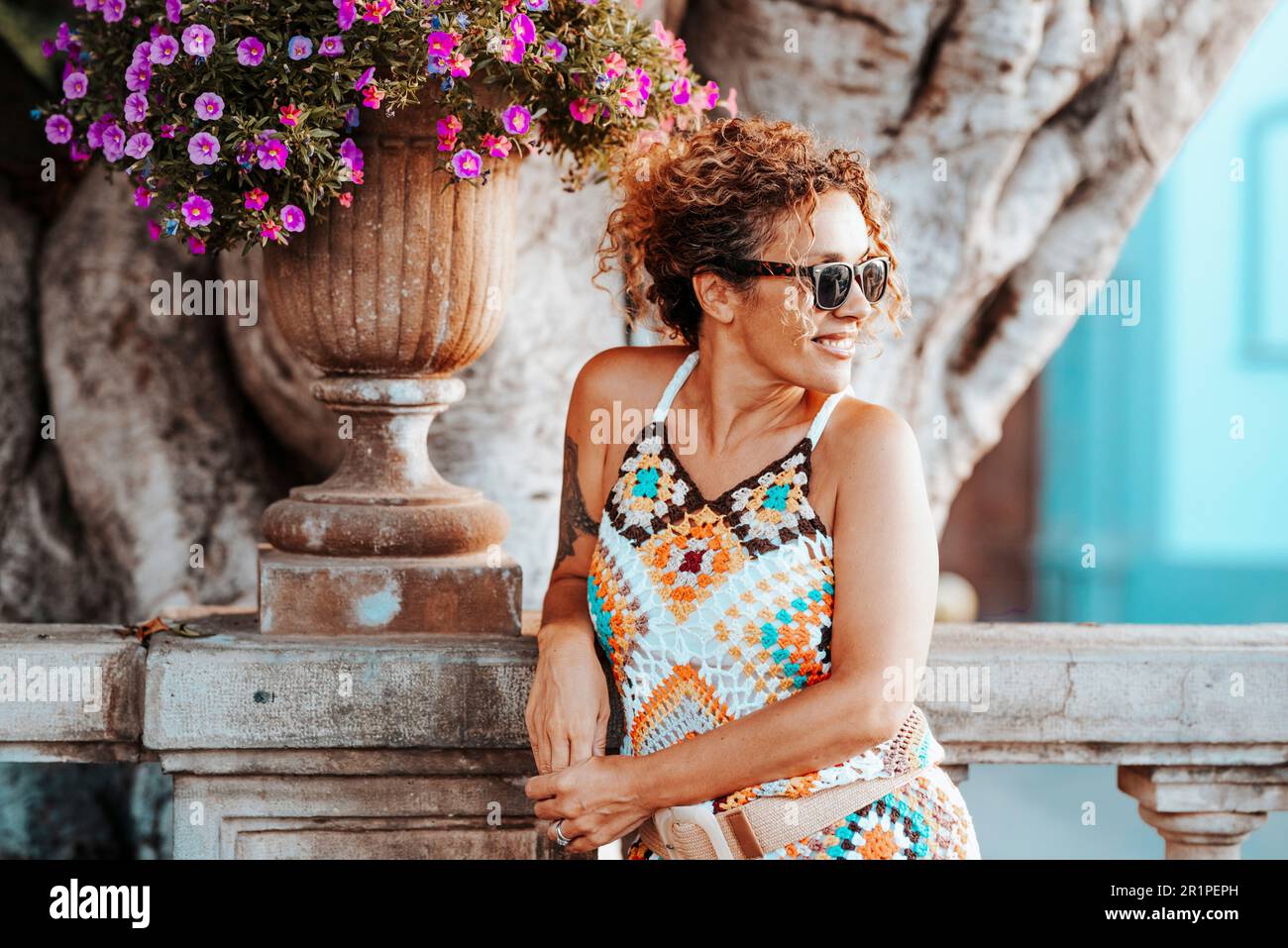 Spensierato felice giovane donna adulta sorriso in attività all'aperto di svago da solo in attesa di ragazzo. Estate stile colorato casual abiti allegro ragazza turista persone con stile di vita e stile moderno Foto Stock