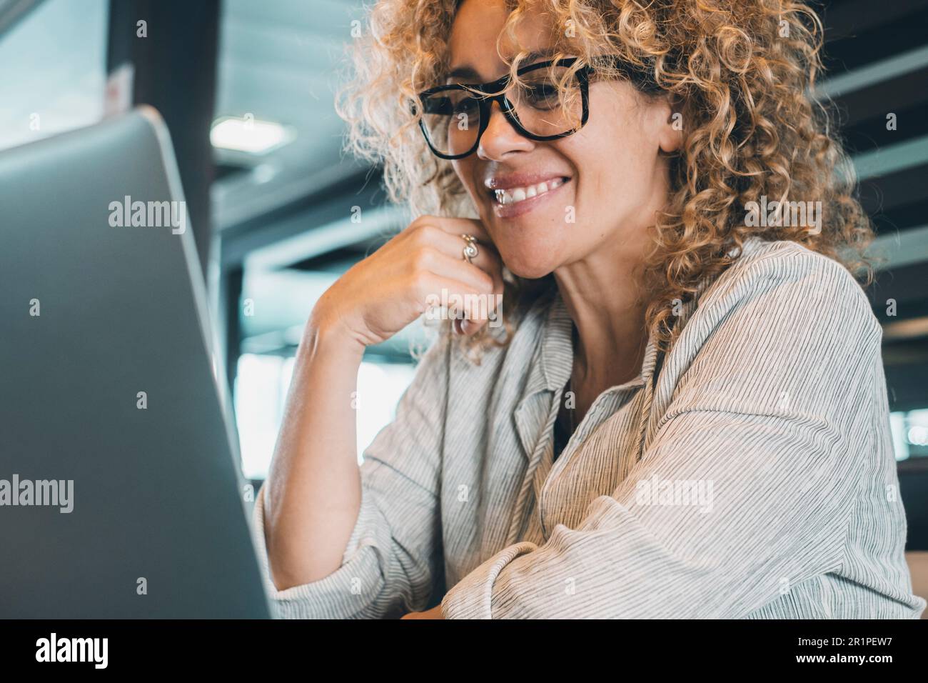 Ritratto di giovane donna adulta allegra, latop in ufficio. Donna d'affari fiduciosa con occhiali sorridere al display del computer. Videochiama la conferenza online. Attraente imprenditore allegro Foto Stock