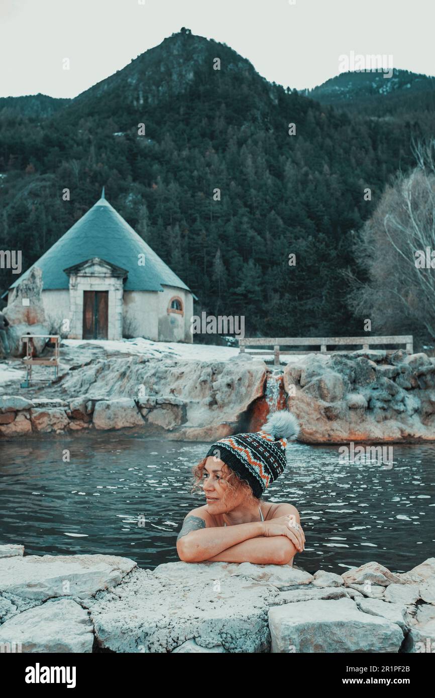 Donna che si rilassa all'interno di una piscina naturale acqua termale calda vulcanica in bella campagna a lato montagna luogo panoramico. Alternativa stile di vita sano e benessere attività ricreative all'aperto donne persone Foto Stock