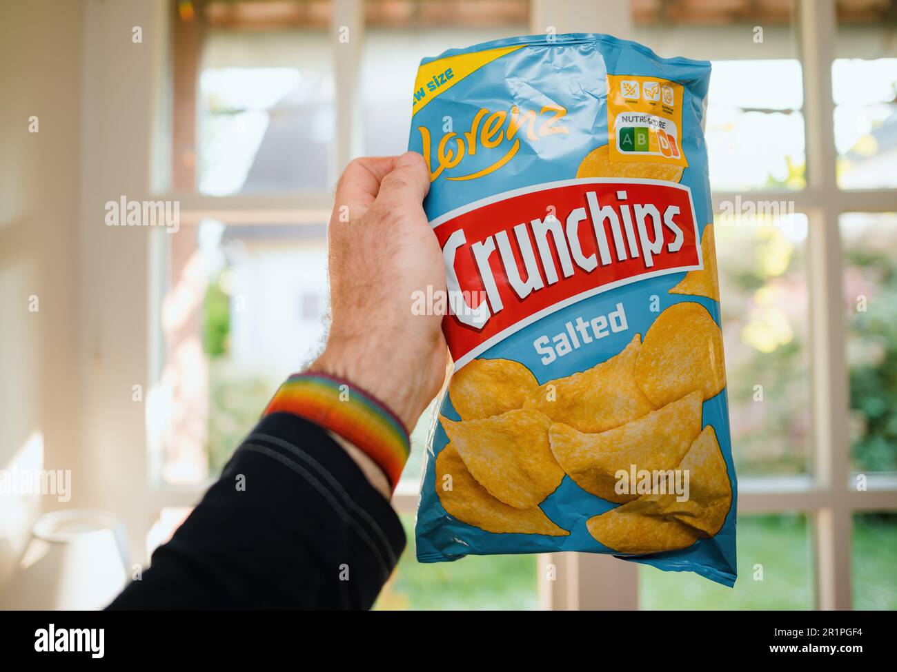 Parigi, Francia - 2 maggio 2023: Una mano di mans tiene una borsa di Crunchips salate di Lorenz, pronti a gustare il loro snack salato bontà sfondo cucina Foto Stock