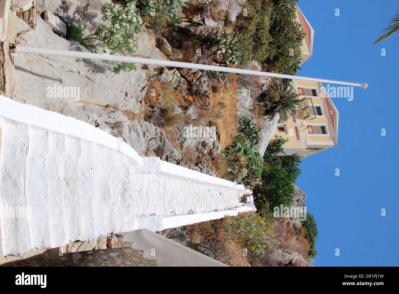 Grecia, Symi, porto villaggio Gialos, scale per una casa residenziale, l'essere umano, flagpole, ripido Foto Stock