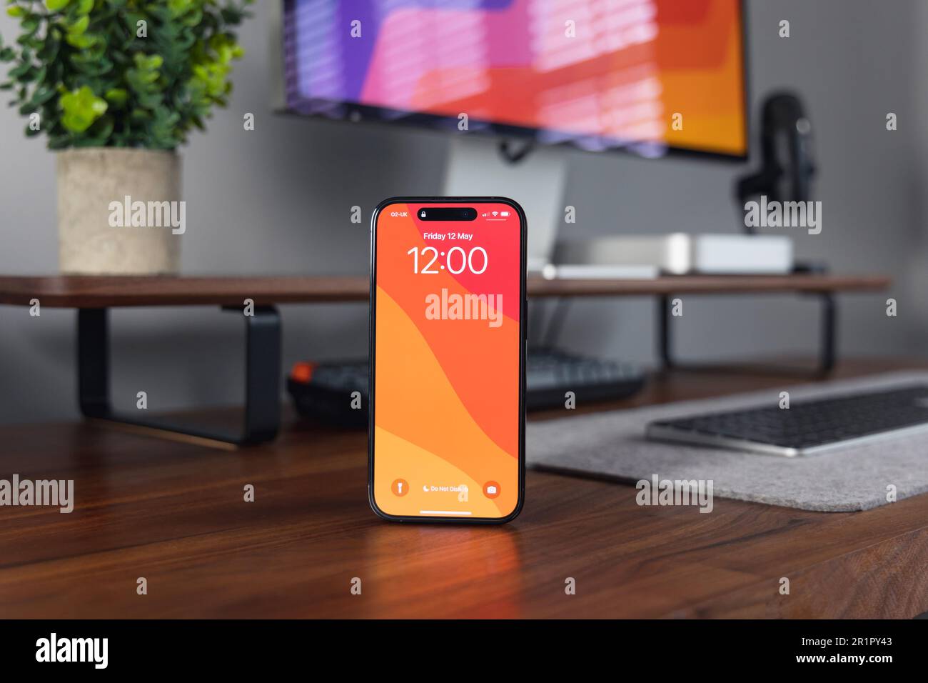 LONDRA - 12 MAGGIO 2023: Apple iPhone 14 Pro con sfondo in legno home Office configurazione minima della scrivania Foto Stock