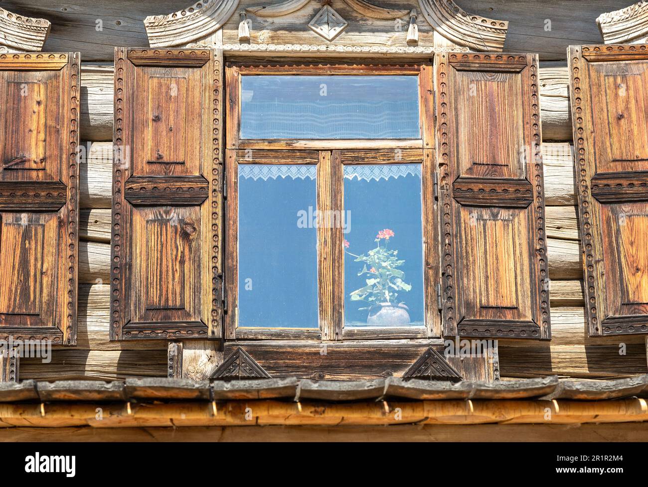 Finestre di vecchia casa di tronchi tradizionale russa con rivestimento in legno intagliato Foto Stock
