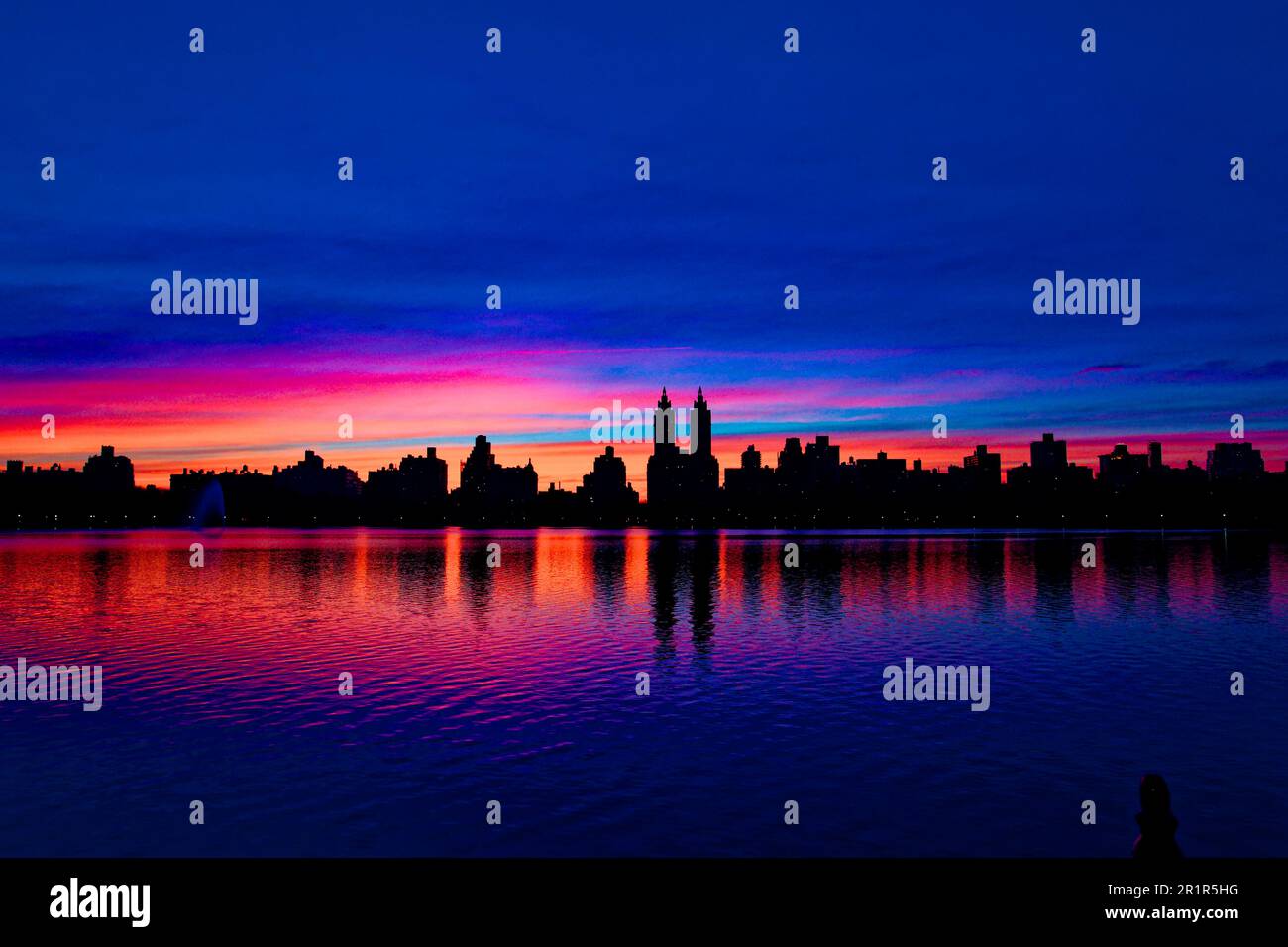 Il tramonto al giacimento Jacqueline Kennedy Onassis, nel Central Park di New York, si staglia sull'iconico skyline di Central Park West. Foto Stock