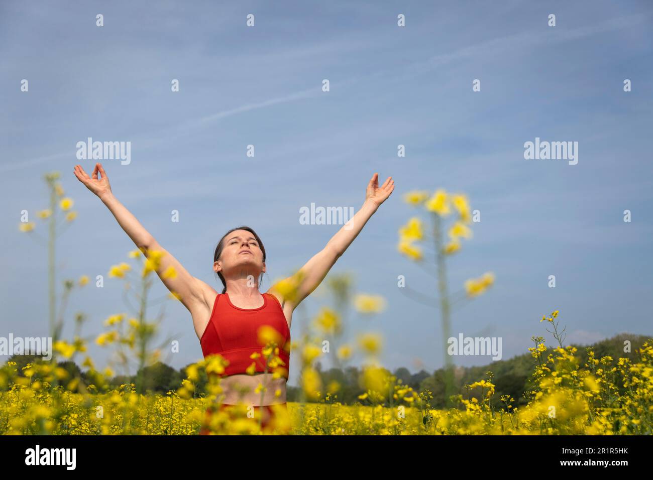 donna che celebra la vita in piedi in natura con le braccia sollevate Foto Stock