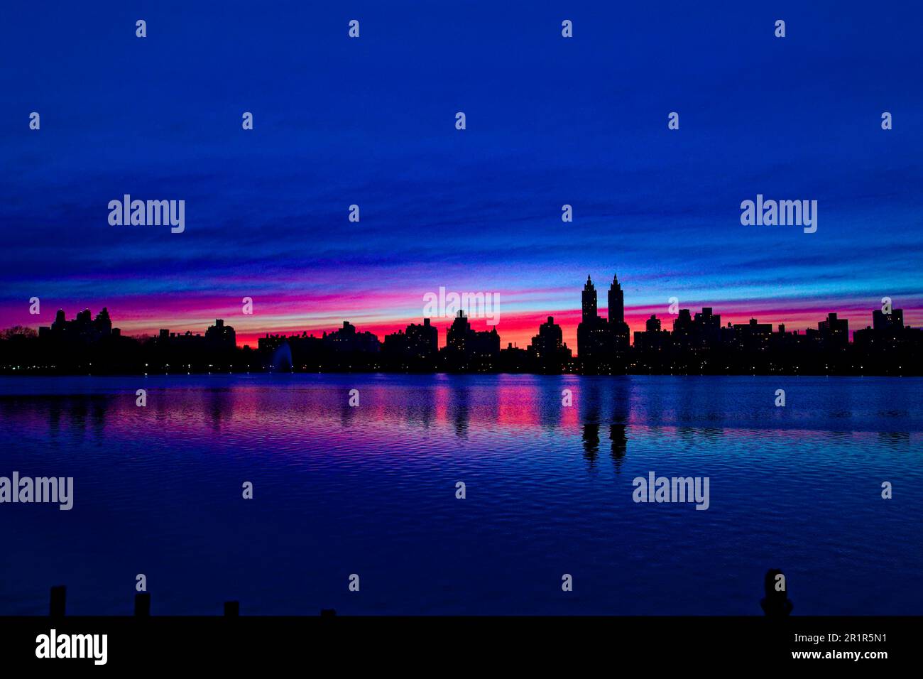 Il tramonto al giacimento Jacqueline Kennedy Onassis, nel Central Park di New York, si staglia sull'iconico skyline di Central Park West. Foto Stock
