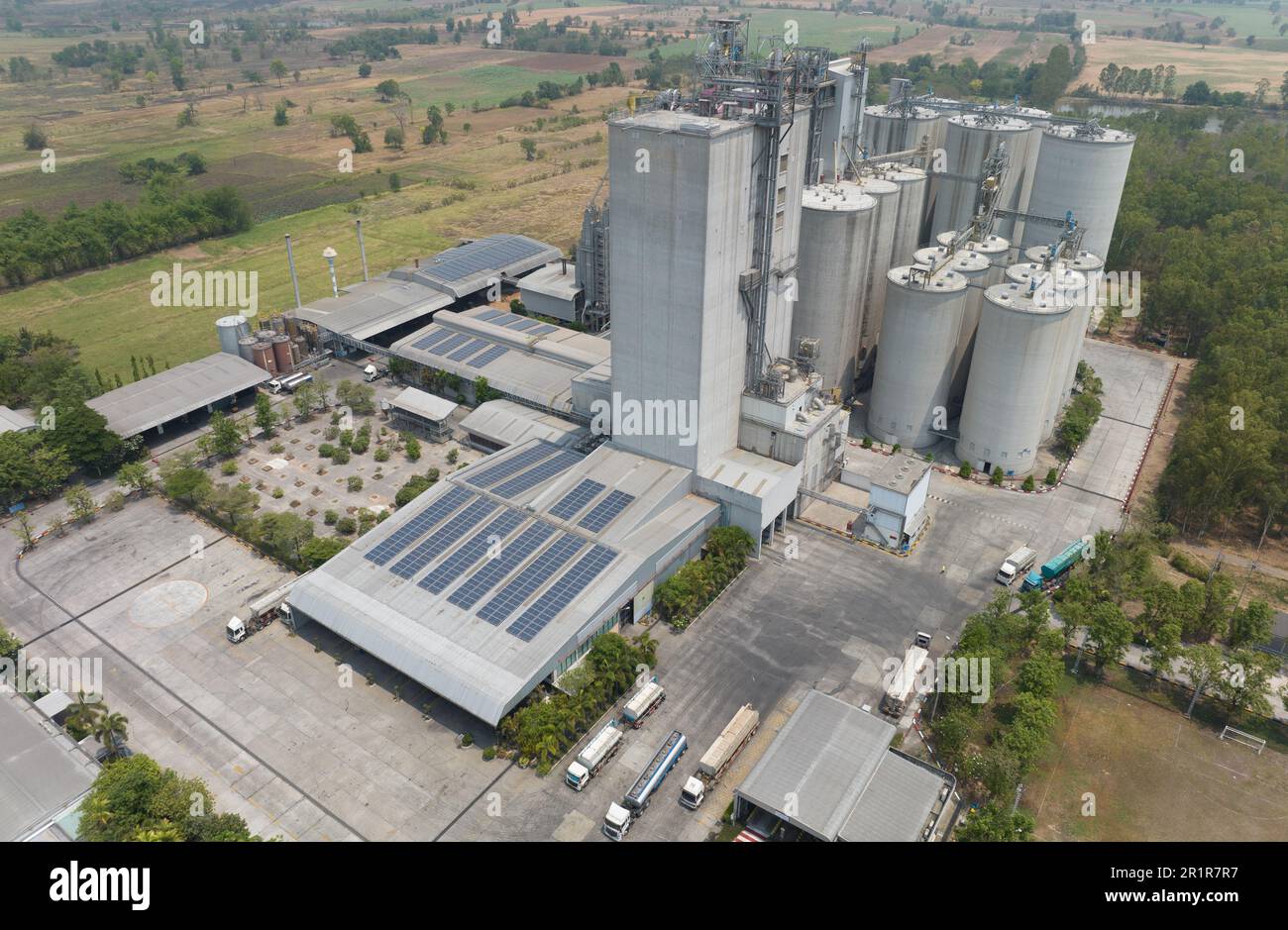Vista aerea della fabbrica di mangimi. Silos agricoli, silos di deposito di grano e pannelli solari sui tetti di impianti industriali. Paesaggio industriale. Agri Foto Stock