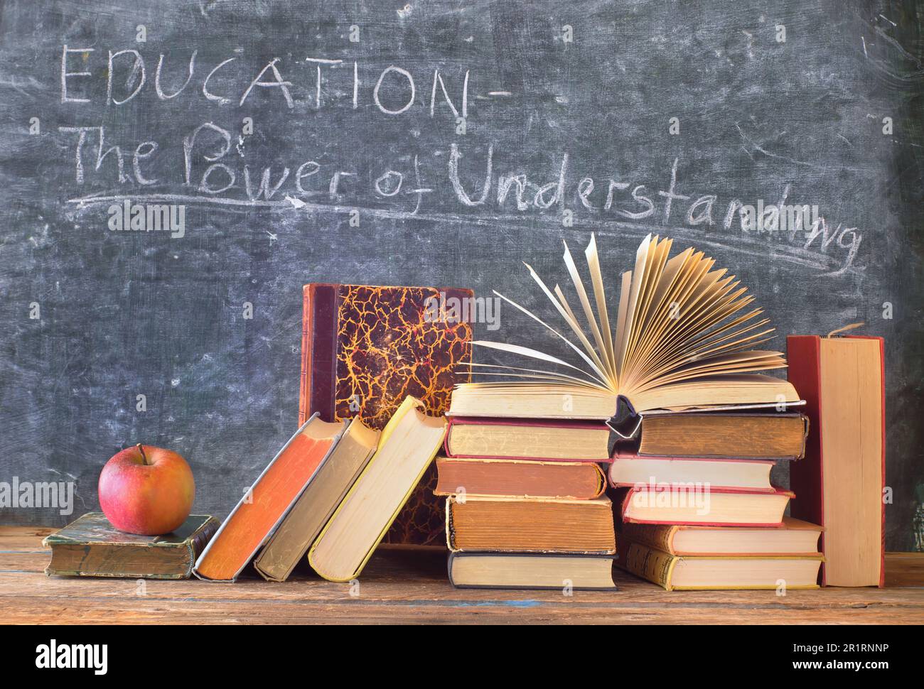 Stack di libri hardback con slogan di fronte a un blackboard.Learning, l'istruzione, la lettura, il ritorno al concetto di scuola. Foto Stock