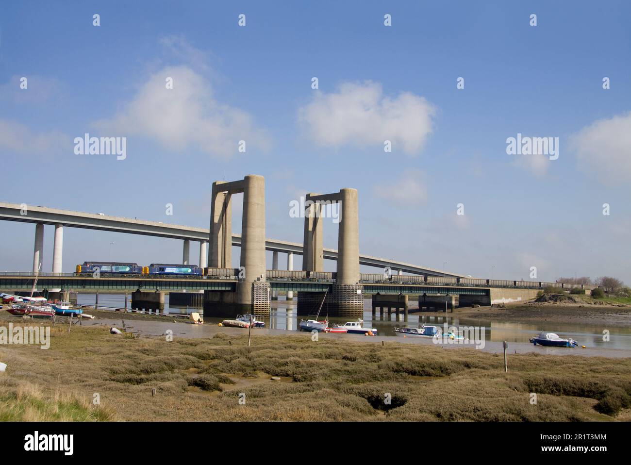 Una coppia di locomotive diesel DRS classe 37 numeri 37667 e 37510 che attraversano il ponte di Kingsferry vicino a Swale con un treno di carri a tramoggia per carrelli. Foto Stock