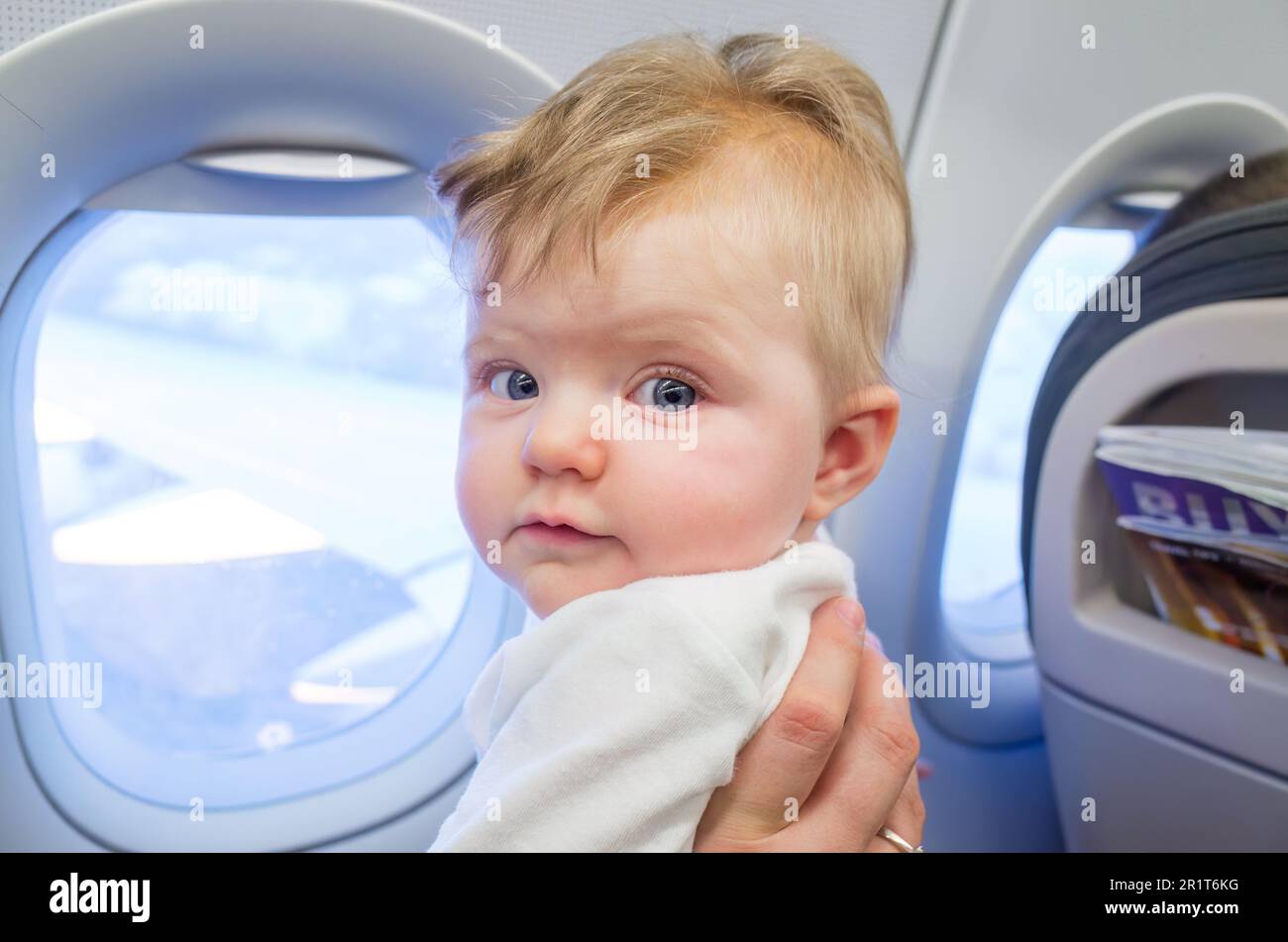 Madre che viaggia su un aereo con una bambina di sei mesi Foto Stock