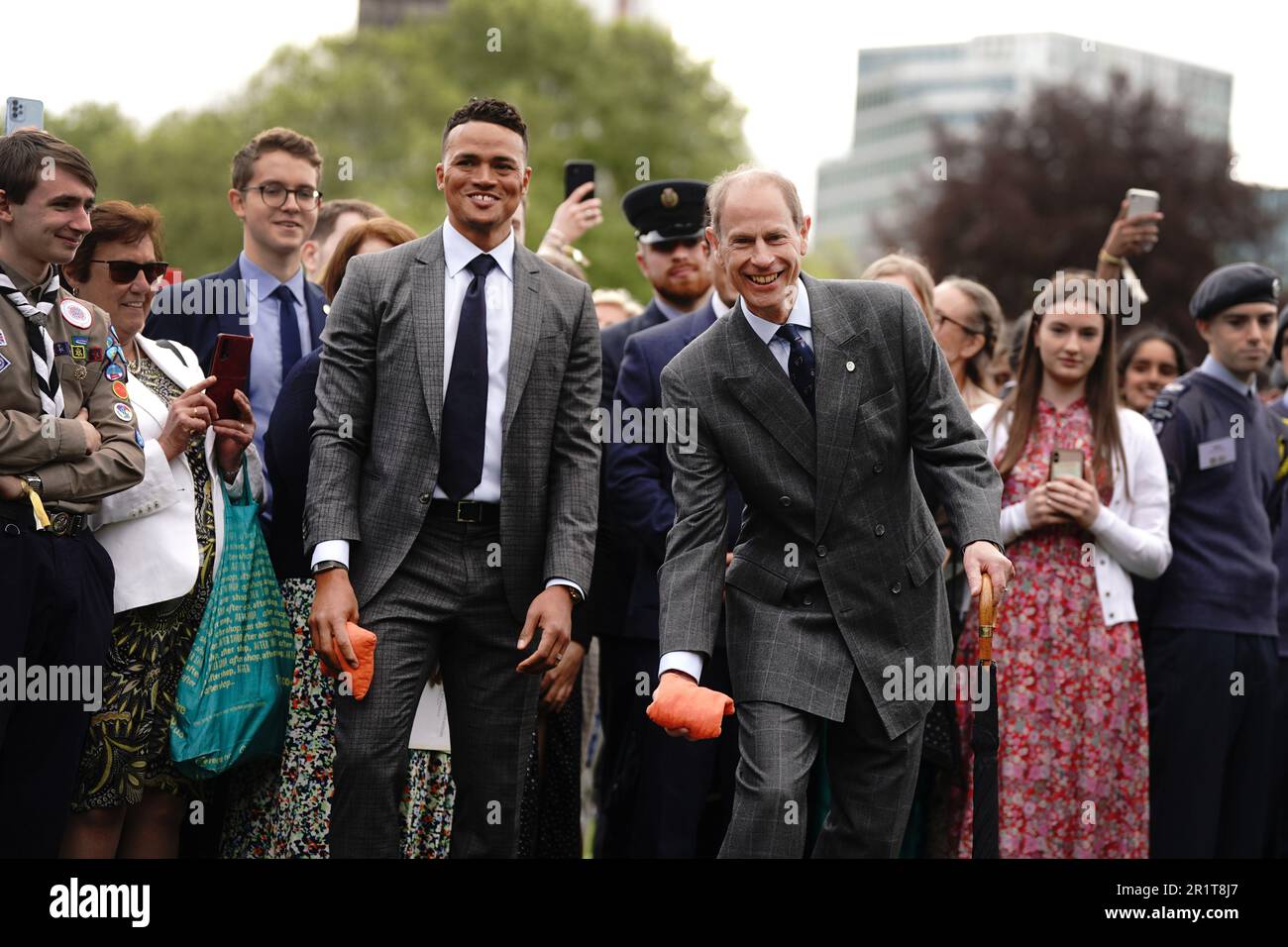 Il Duca di Edimburgo reagisce durante un gioco di 'cornhole' con l'ex calciatore professionista e il pundit TV Jermaine Jenas (a sinistra), mentre ospita giovani del Duca di Edimburgo nel giardino di Buckingham Palace, Londra. Data immagine: Lunedì 15 maggio 2023. Foto Stock