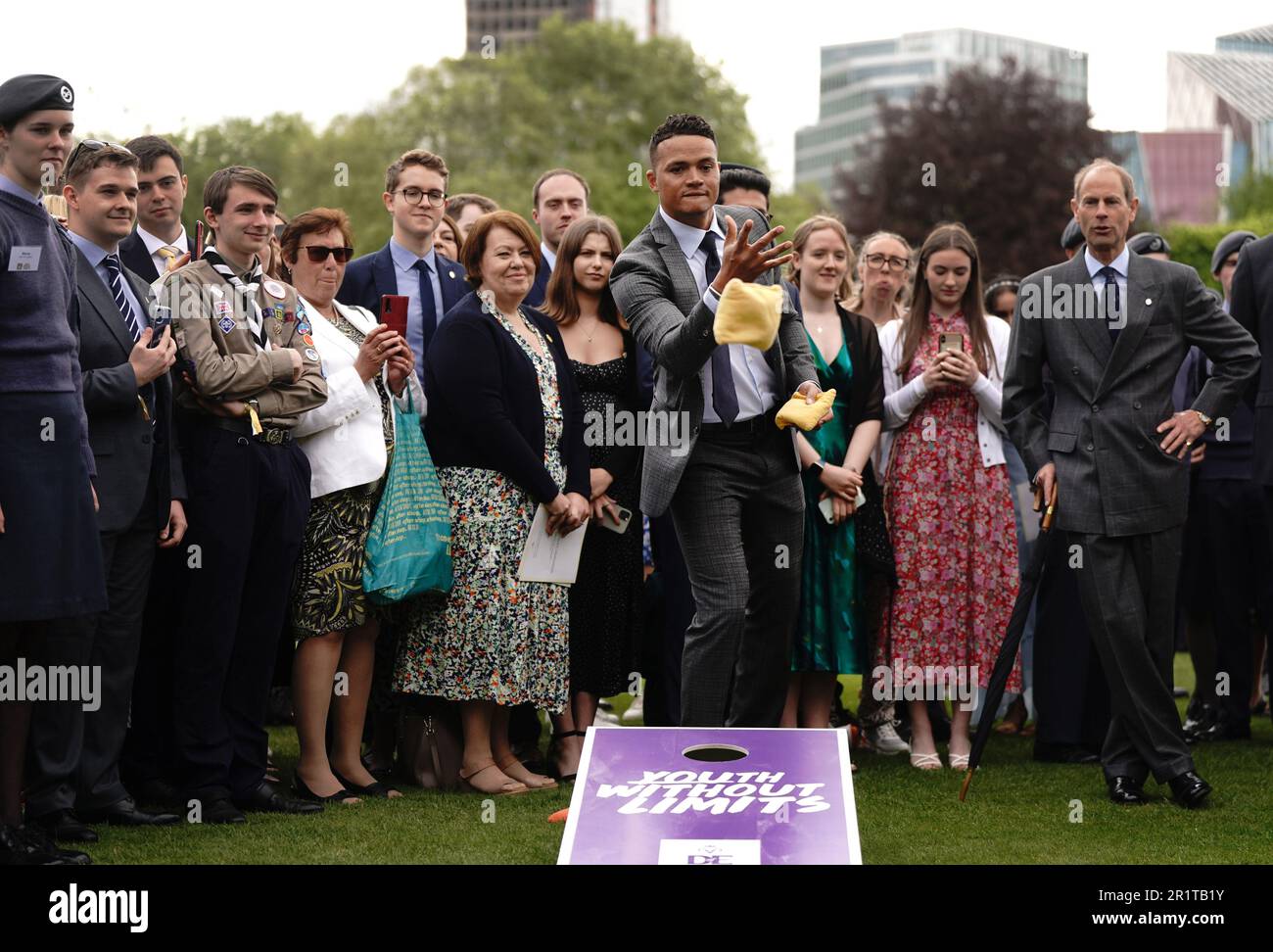 Il Duca di Edimburgo (a destra) reagisce durante un gioco di 'cornhole' con l'ex calciatore professionista e il pundit televisivo Jermaine Jenas (al centro), mentre ospita i giovani del Duca di Edimburgo's Award Scheme nel giardino di Buckingham Palace, Londra. Data immagine: Lunedì 15 maggio 2023. Foto Stock