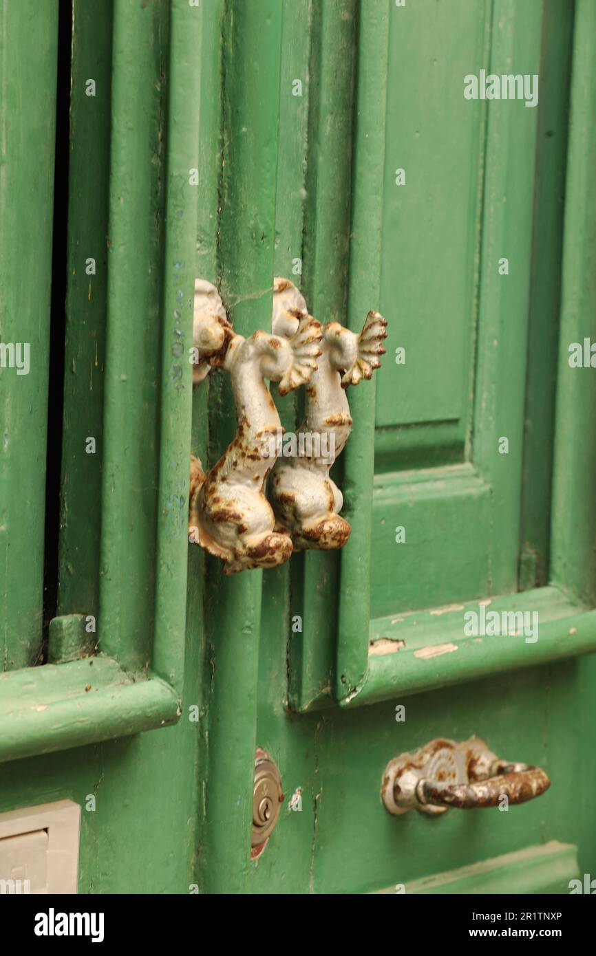 Maniglie per porte Dolphin su vecchie porte di legno, Città Vecchia, Lagos, Algarve, Portogallo Foto Stock