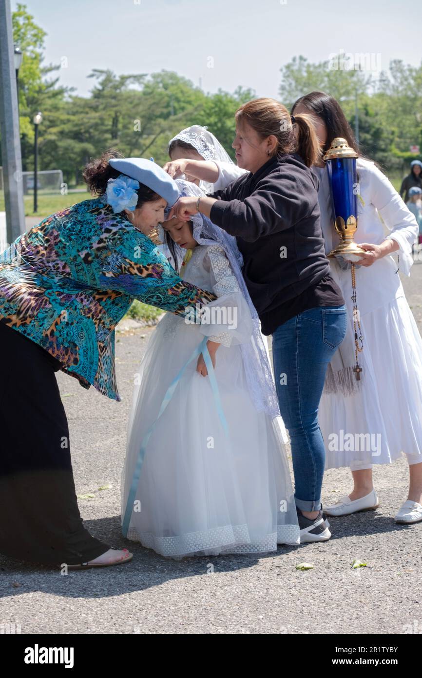 Appena prima dell'incoronazione di maggio della Vergine Maria, la ragazza che farà l'incoronazione ottiene una regolazione del guardaroba. Nel Flushing Meadows Park nel Queens. Foto Stock