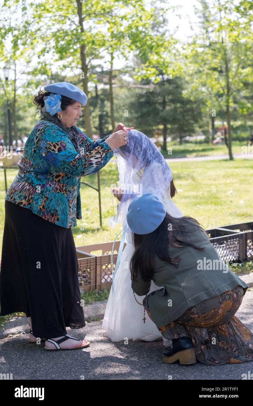 Appena prima dell'incoronazione di maggio della Vergine Maria, la ragazza che farà l'incoronazione ottiene una regolazione del guardaroba. Nel Flushing Meadows Park nel Queens. Foto Stock