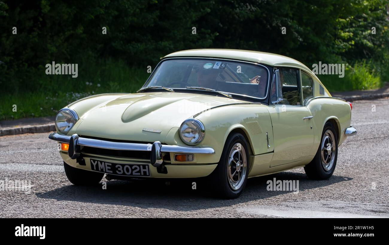 Stoke Goldington, Northants, Regno Unito - Maggio 14th 2023. 1970 giallo TRIONFO GT6 classica auto sportiva che attraversa un villaggio inglese Foto Stock