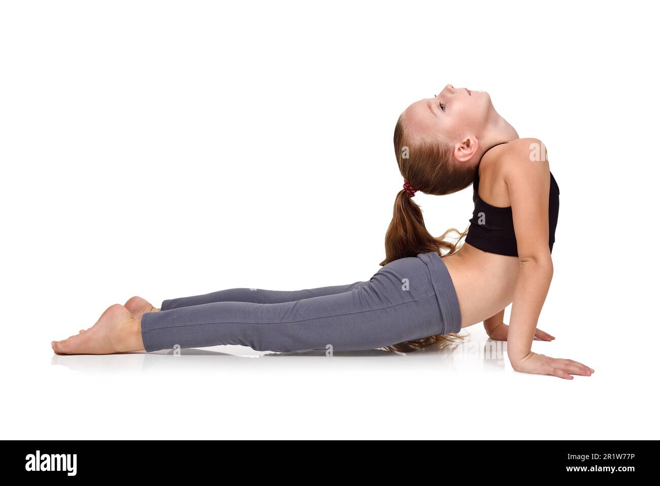 bambina che fa esercizi di yoga su sfondo bianco Foto Stock